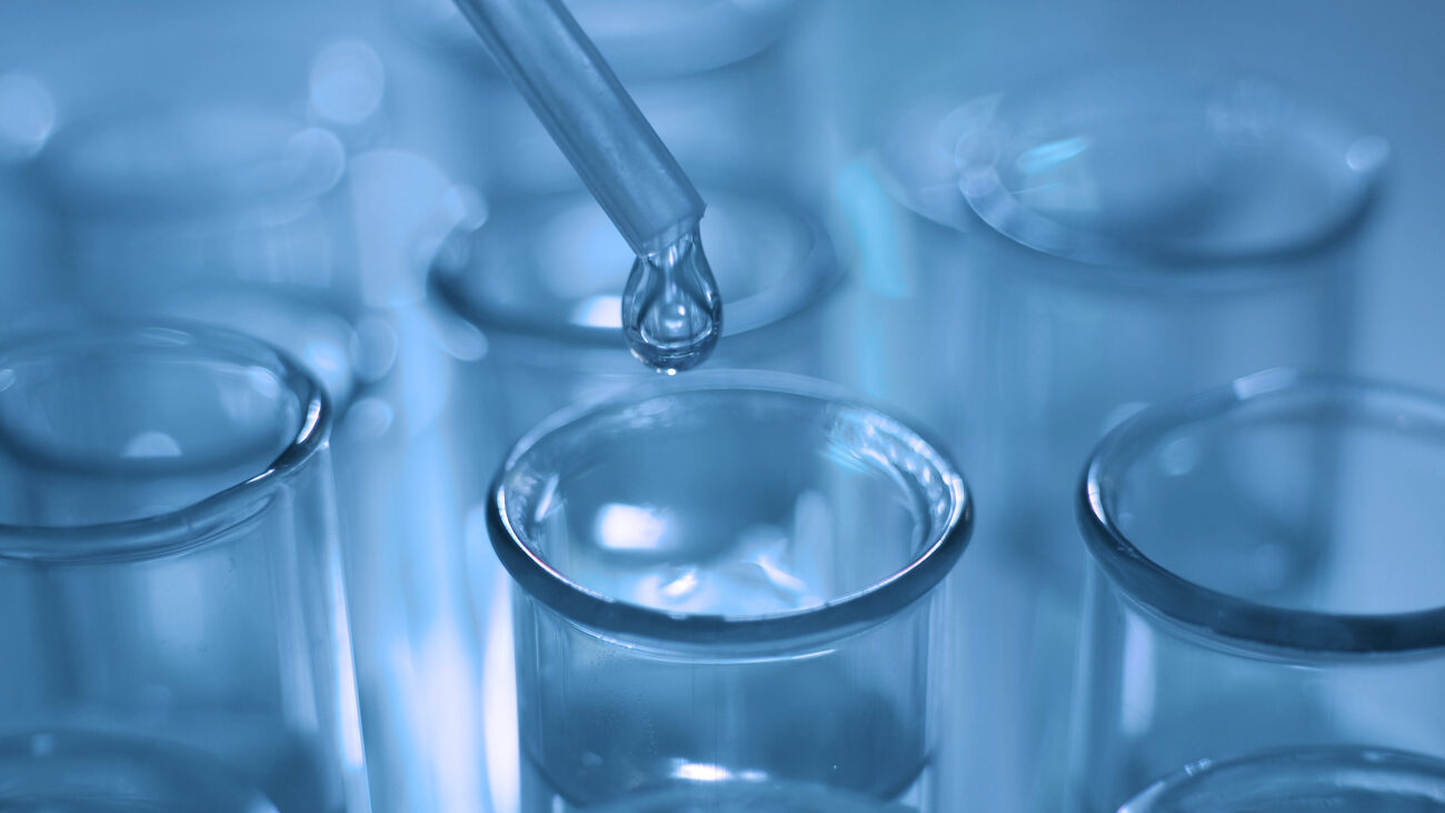 Dropping chemical liquid to test tubes for lab testing, science laboratory research